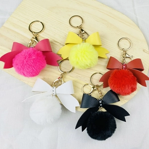 Set of colorful faux fur pompom keychains with rhinestone leather bows and gold rings