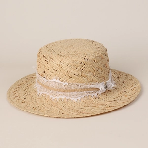 Gros plan détaillé du chapeau canotier en raphia avec dentelle blanche et bordure pompon
