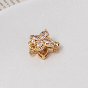 Macro shot of gold plated rotating four leaf flower clasp with zircons for jewelry