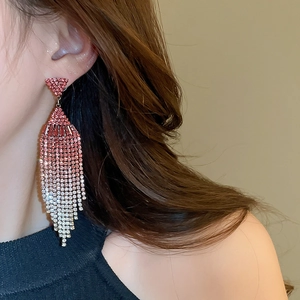 Detailed view of silver needle geometric tassel earrings with pink gradient rhinestones