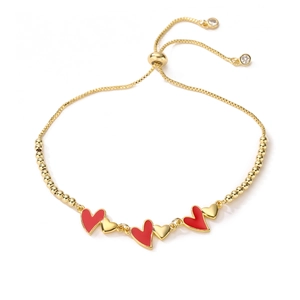 Bracciale a sfere dorate regolabile con ciondoli a cuore smaltati rossi e cristalli
