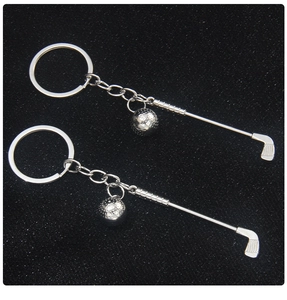 Detailed view of silver metal golf club and ball charms on a keychain with link chain