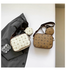 Flat lay of cream and brown camera bags with monogram pattern and matching coin purses