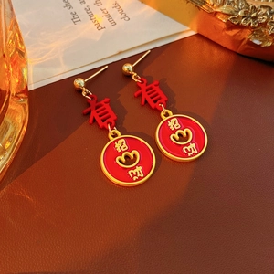 Macro view of vintage red enamel earrings with gold calligraphy and heart details