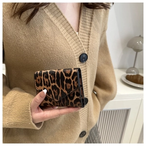 Close-up of leopard print small leather wallet with V-flap in casual lifestyle setting