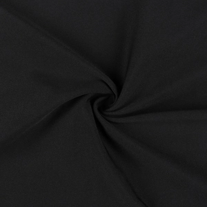 Dettaglio macro del tessuto nero con eleganti pieghe a spirale per abito estivo sottile