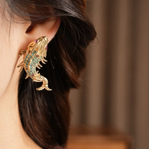 Detail of vintage koi fish earrings with blue and pink crystals on gold plating