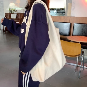 Minimalist large white canvas tote bag shown as a side view on a model in vintage interior