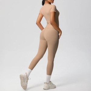 Detail view of tan two-piece athletic set showing compression fit and matte fabric texture