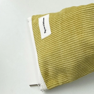 Detailed close-up of yellow corduroy fabric texture and zipper on the organizer pouch