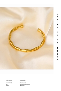 Dettaglio del bracciale a forma di bambù placcato oro 18K su elegante seta beige
