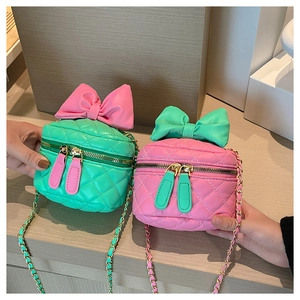 Close-up of quilted chain bags in pink and green with large bows and gold zippers