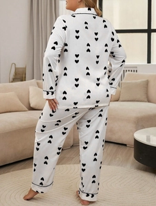 Rear view of white waffle pajamas featuring black heart prints and elegant piping details
