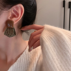 Retro houndstooth fabric fan-shaped earrings with brown square studs worn by a model