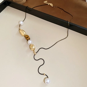 Detailed macro view of tiger eye stone and pearl flower pendant necklace for women