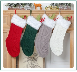 Détail de quatre chaussettes de Noël en tricot avec bordure en peluche sur la cheminée