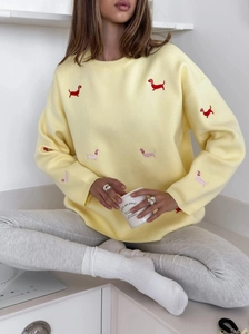 Relaxed pale yellow knit sweater featuring colorful dachshund embroidery and long sleeves
