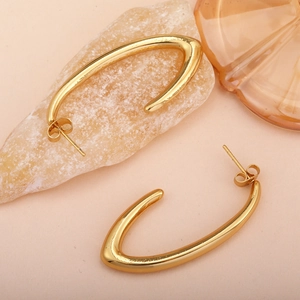 Polished gold C-shaped stainless steel moon earrings on a natural stone background