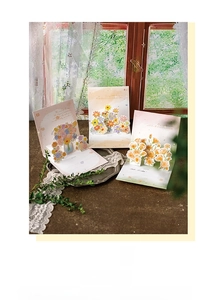 Detailed view of 3D pop-up flower cards featuring sunflowers and carnations on a desk