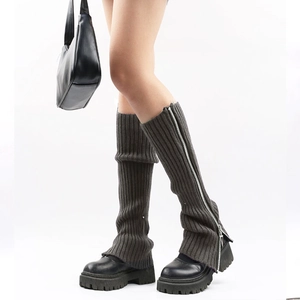 Close-up of dark grey knitted leg warmers featuring a side silver zipper detail