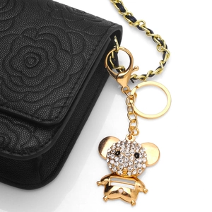 Sparkling rhinestone mouse keychain in gold finish on a black quilted luxury handbag