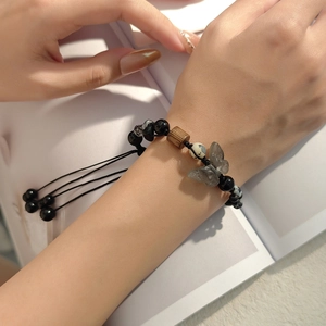 Artistic beaded bracelet with butterfly charm and black beads on female wrist