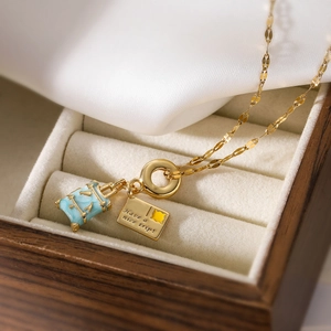 Gold plated suitcase pendant necklace with blue enamel and Have a nice trip engraving