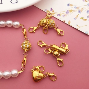 Variety of gold magnetic jewelry clasps including spherical and heart shapes with lobster claw