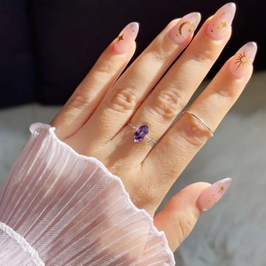 Detailed close-up of a marquise-cut purple gemstone ring with a twisted silver band