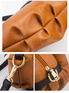 Detail shot of brown leather texture with golden hardware and black strap accents