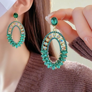 Macro detail of vintage green hollow oval earrings with gold plating and crystals