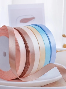 Detailed close-up of colorful 1cm polyester satin ribbon rolls for gift wrapping