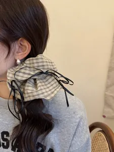 Detail of plaid fabric scrunchie with black ribbons on a ponytail hairstyle