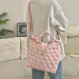 Detail view of quilted pink tote bag featuring cute rabbit and cherry floral patterns
