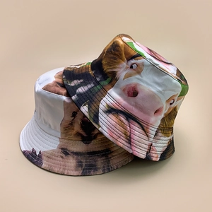 Reversible bucket hat with animal prints featuring cow and sloth photography designs