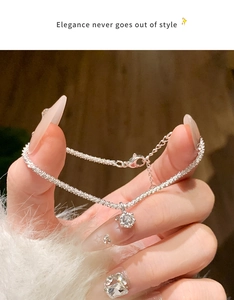 Close-up of elegant silver bracelet with a sparkling crystal pendant on a wrist