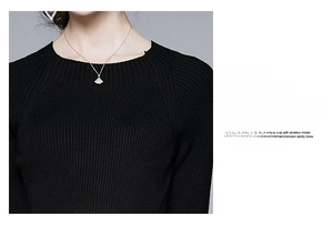 Détail de robe en maille côtelée noire à col rond avec collier pendentif en éventail