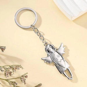 Silver metal angel girl keychain featuring floral relief and heart detail on beige background
