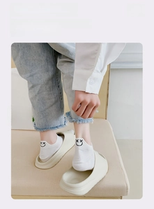 Detail of white low cut socks with cute smiley embroidery and elastic anti-slip cuff