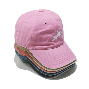 Detail of embroidered rabbit motif on cotton baseball caps in various colors