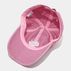 Detail view of pink washed cotton baseball cap interior with 100% cotton label