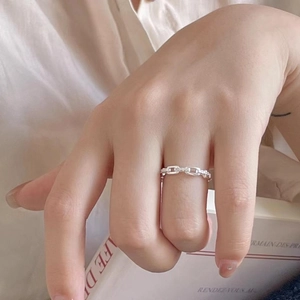 Anello a catena minimalista in argento sterling 925 indossato con sfondo di un libro