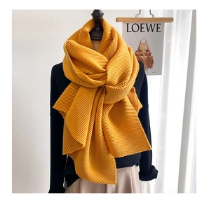 Macro shot of bright yellow accordion pleats on long brushed scarf with rich texture