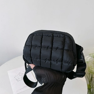 Detail of black quilted waist bag featuring premium padding and adjustable buckle strap