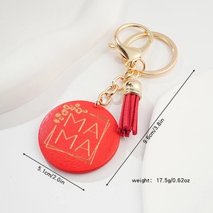 Detail of red round wooden keychain with gold MAMA engraving, tassel, and dimensions