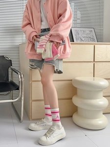 Close-up of pink striped crew socks with cute bear embroidery and ribbed cotton texture