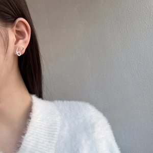 Close-up of butterfly wing silver stud earrings on model featuring minimalist hollow lines