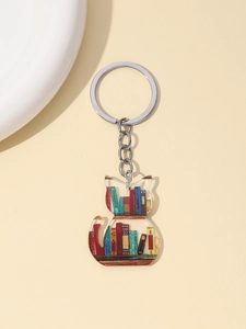 Detail of a transparent acrylic cat keychain with colorful book patterns and silver ring