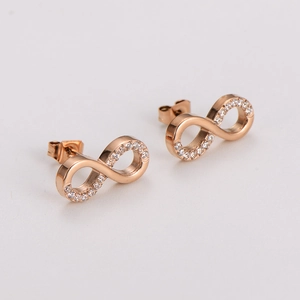 Vue macro des boucles d'oreilles signe infini or rose avec cristaux pavés étincelants