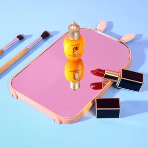 Pink rabbit ear foldable desktop makeup mirror with a minimalist light blue background